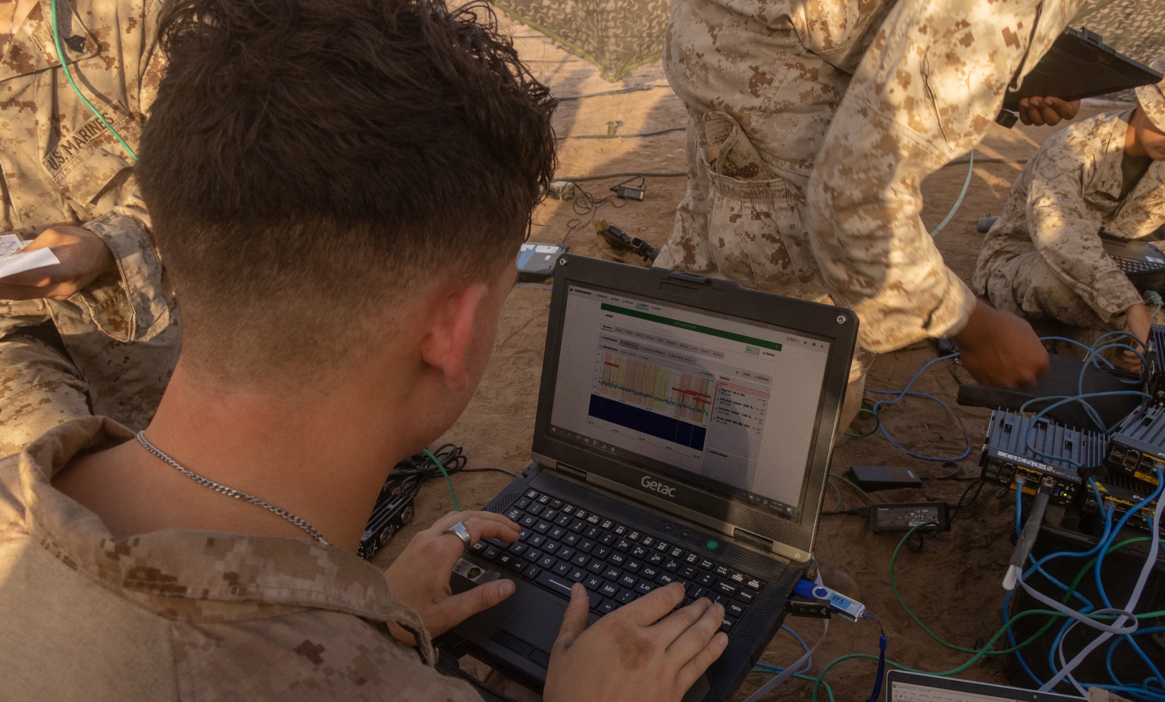 A Marine running SEIDR from a laptop at a desert field site